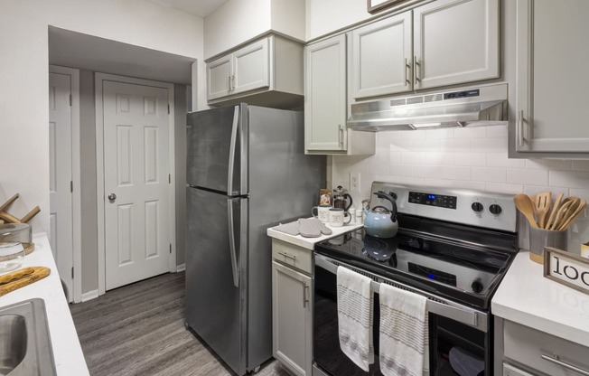 Apartment kitchen with quartz counter tops and stainless steel appliances at Woods of Fairfax