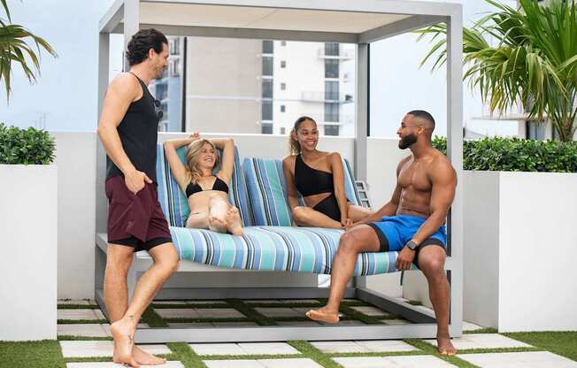 A group of people are sitting and standing on a patio. at Palma, Florida