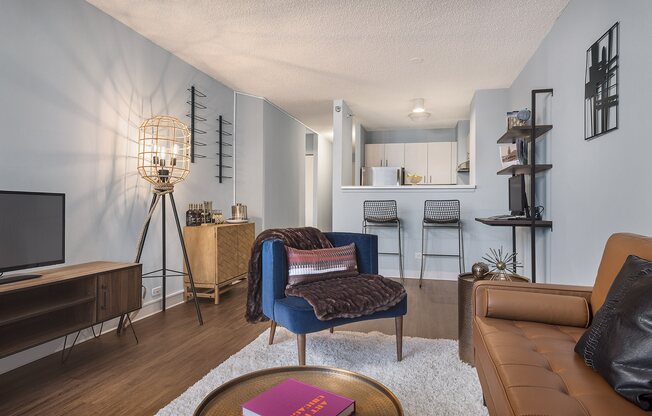 A living room with a blue chair and a brown couch.