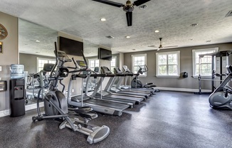 fitness center with cardio equipment and free weights