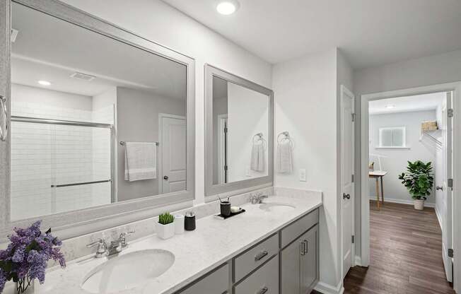 a white bathroom with two sinks and mirrors