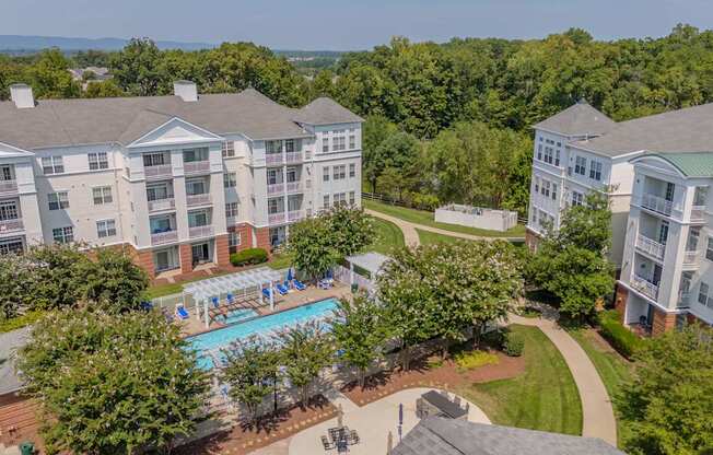 An aerial view of a resort with a swimming pool and trees.