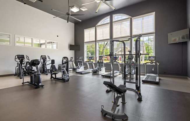 A gym with a variety of exercise equipment and a fan.