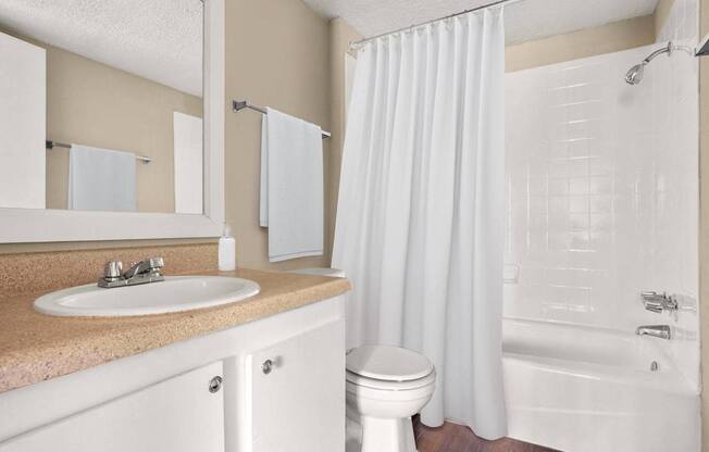 A white bathroom with a sink, toilet, and bathtub.