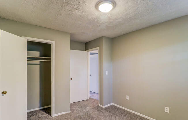 A small, empty room with a white door and a white cabinet.