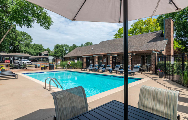 Pool with striped lounge chair and umbrella at Springhill Apartments, Kansas, 66213