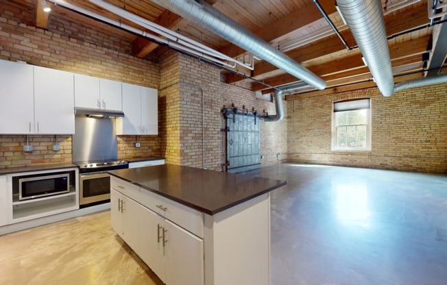 a kitchen with a large island and brick walls