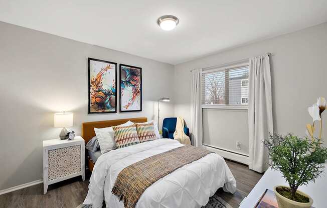 A bedroom with a large bed and two framed pictures on the wall.