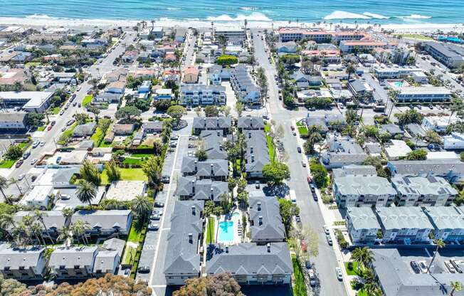 an aerial view of a city with the ocean in the background