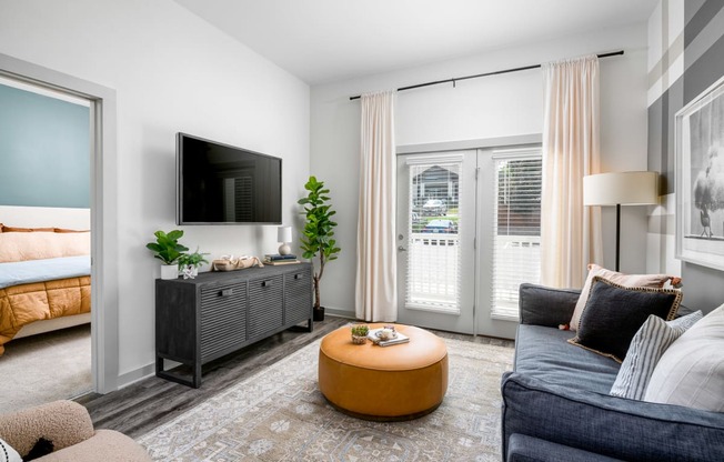 a living room with a tv and a door that leads to a bedroom