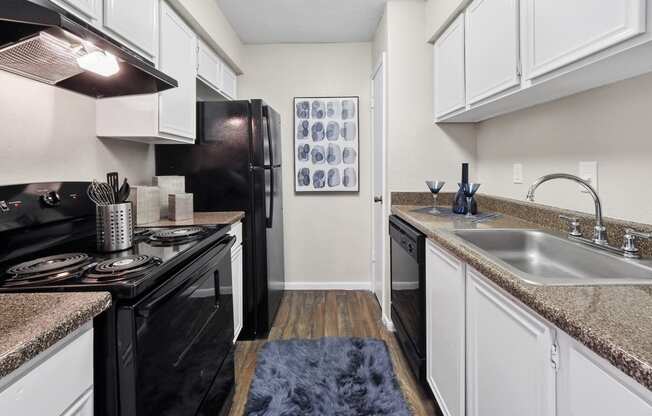 a kitchen with white cabinets and black appliances