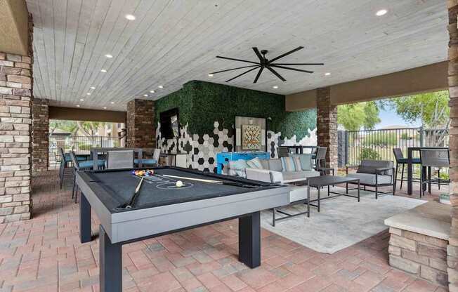 A pool table is in the middle of a room with a ceiling fan. at The Laurel Apartments, Arizona, 85286