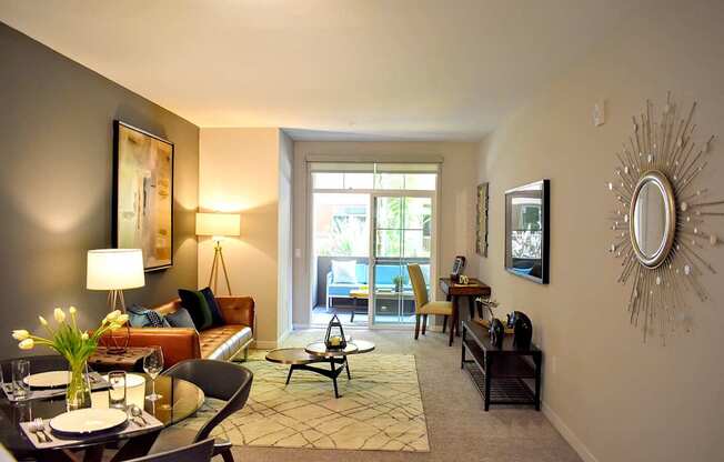 A well-lit living room with a glass dining table and chairs.