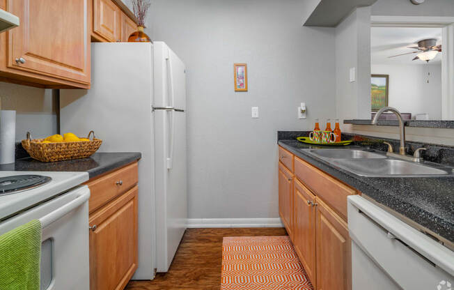 a kitchen with white appliances and granite counter tops