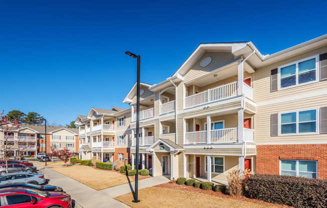 a row of apartment buildings with cars parked in front of them