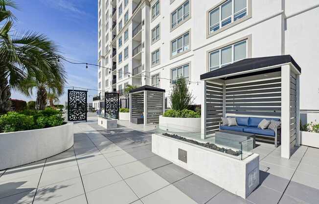 Relaxing outdoor cabanas with firepits in front at Dominion Post Oak apartments in Houston, TX