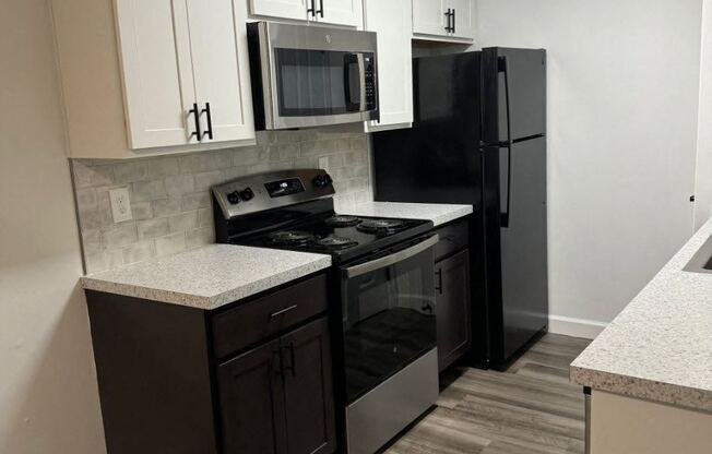 a kitchen with black appliances and white cabinets