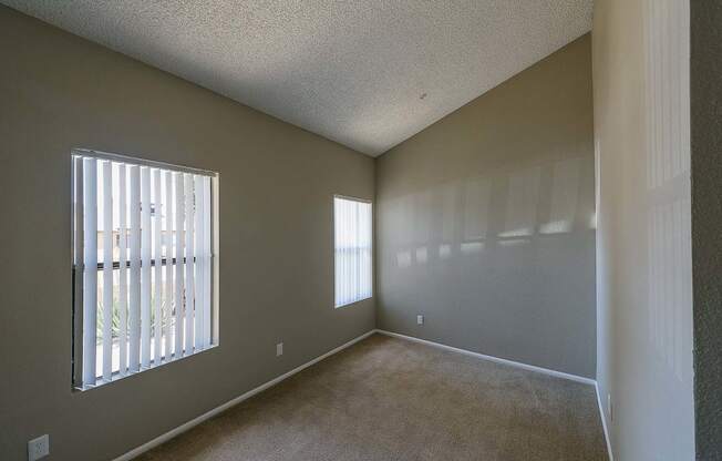 an empty living room with a large window and carpet