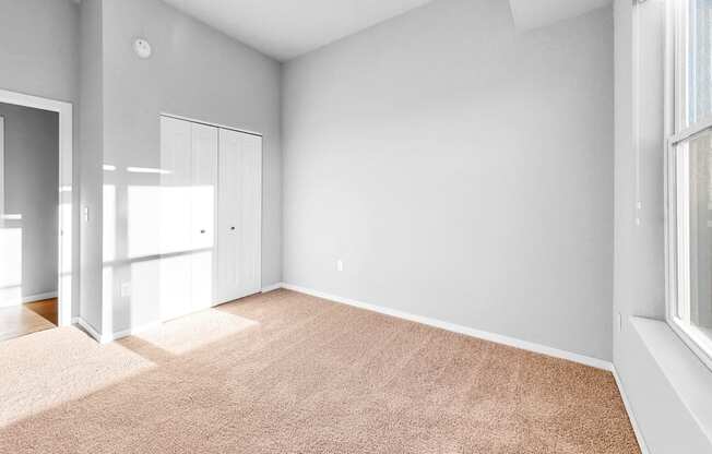 A room with a carpeted floor and a window.