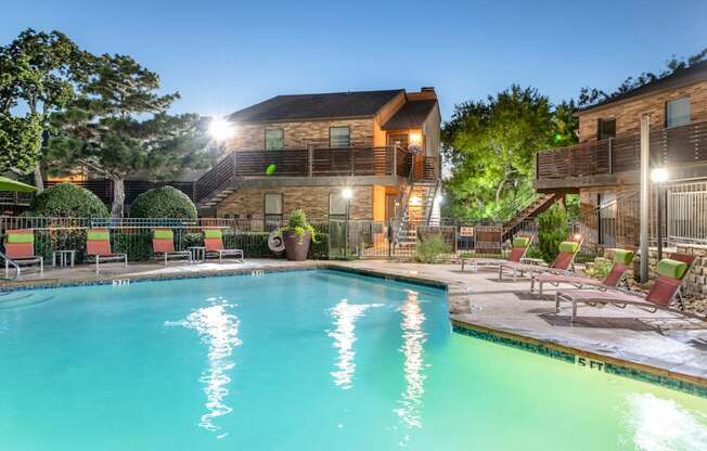 Swimming pool in front of apartments at dusk at Vine Apartments in Arlington, TX