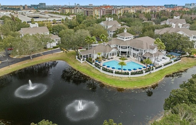 an aerial view of the clubhouse with a pool and water fountain