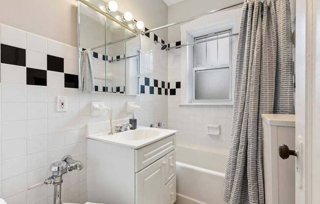 a bathroom with a sink and a mirror and a shower at The Bryant at Oak Park I & II, Illinois