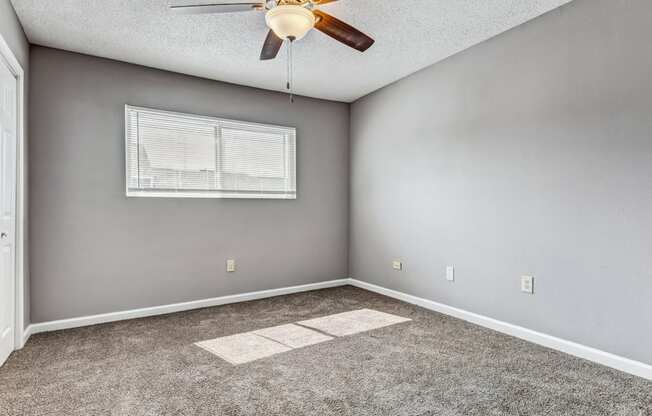 Whitney Manor Apartments in Gretna, LA photo of bedroom with plush carpeting and ceiling fan