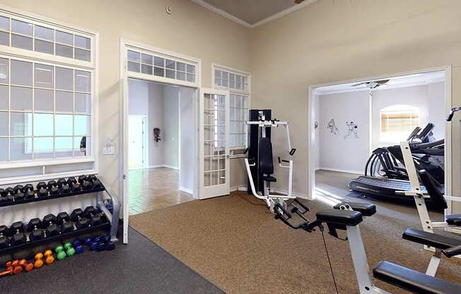 an apartment gym with a treadmill and weights