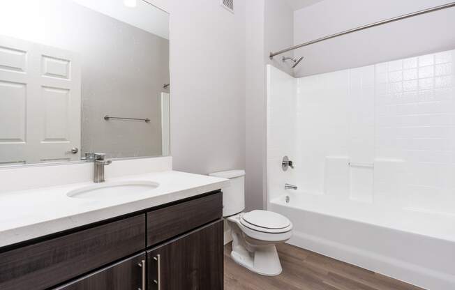 a bathroom with a toilet sink and shower and a mirror