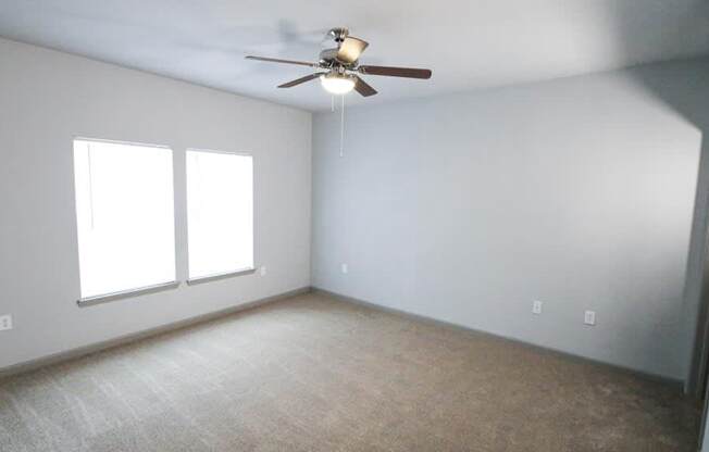 Bedroom with a ceiling fan and two windows at Mosaic Apartments in Avon, Indiana