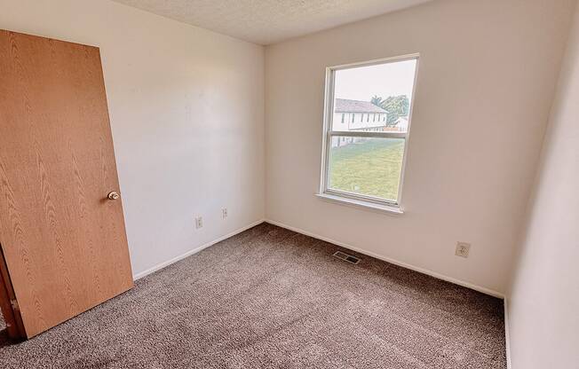 an empty room with a window and a door