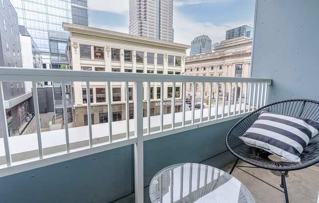 a balcony with two chairs and a table and a view of the city