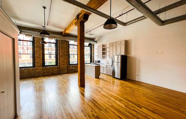 A large empty room with wooden floors and exposed ceiling beams.