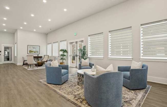 A spacious living room with grey couches and a rug.