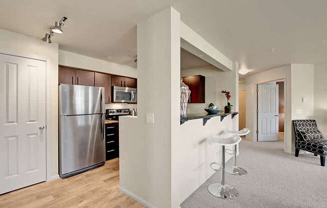 A kitchen with a refrigerator, stove, and microwave. at Mill Creek Meadows Apartments, Mill Creek, WA