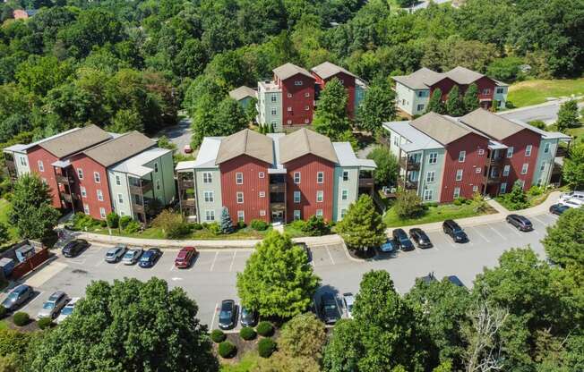 an aerial view of an apartment complex with cars parked in a parking lot at River Mill Lofts & Skyloft, North Carolina, 28803