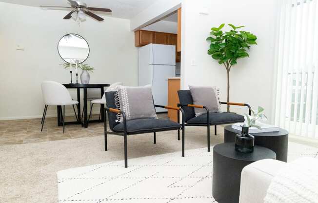 a living room with a dining area and a kitchen with a table and chairs