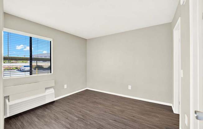 A room with a window overlooking a highway.