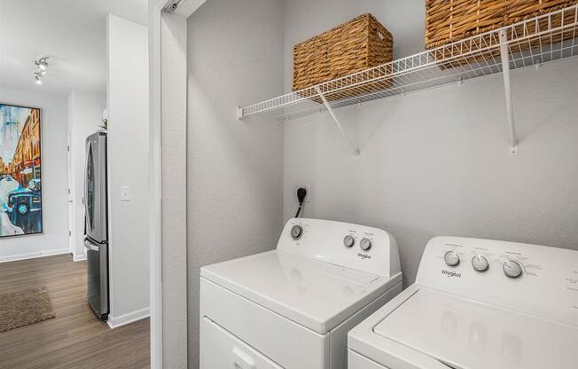 a white laundry room with two washes and a dryer