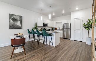 a kitchen and dining area with white cabinetry and a stainless steel refrigerator