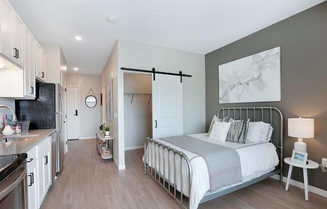 carpeted bedroom with sliding barn door and gray accent wall