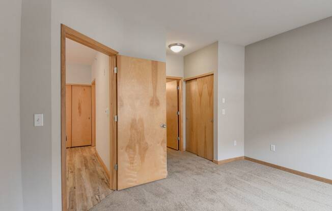 an empty room with wooden doors and a carpeted floor