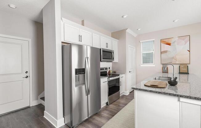 A bright, streamlined kitchen at Amavi Kissimmee features stainless steel appliances and generous counter space, creating a clean, inviting place to start and end each day.