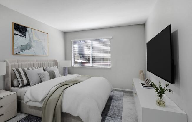 a white bedroom with a large bed and a tv
