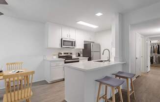 A modern kitchen with a white island and wooden stools.