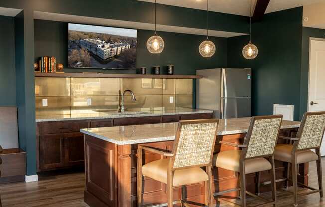 a kitchen with a bar and chairs and a refrigerator