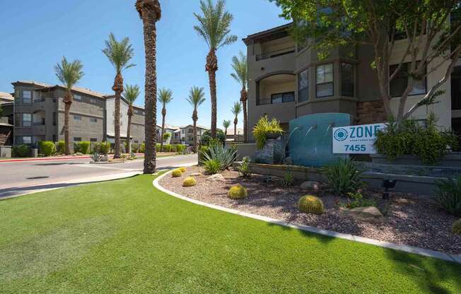 A grassy area in front of apartment buildings with a sign that says Zone 4455.