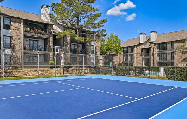 an outdoor tennis court at the enclave at woodbridge apartments in sugar land, tx