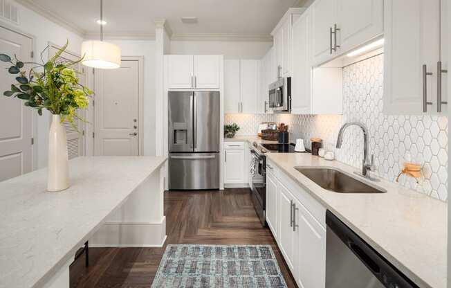 a large white kitchen with stainless steel appliances