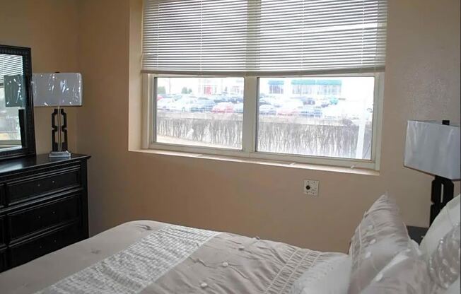 a bedroom with a large window and a bed